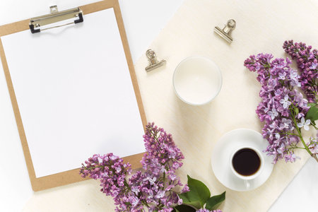 Flat lay with pad, paper, clips, coffee and lilacの写真素材