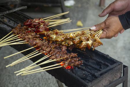 Chicken satay grill at a busy street food marketの写真素材