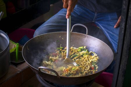 Delicious fried noodles at a busy street food marketの写真素材