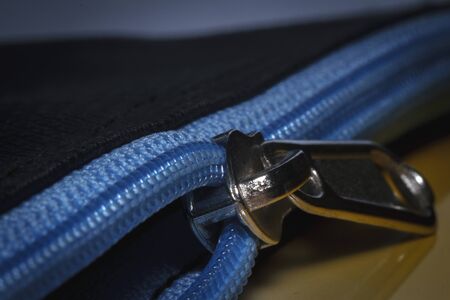 Close-up of a blue zipper on the black pouchの写真素材
