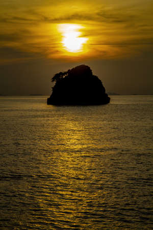 A silhouette small remote island in the middle oceanの写真素材