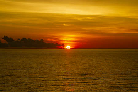Beautiful ocean view with a dramatic cloudy sky golden sunsetの写真素材