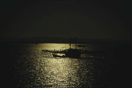 A silhouette Indonesian traditional outrigger fishing platform under the bright sun, Raja Ampat, West Papuaの写真素材