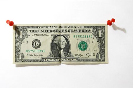 one dollar banknote fixed on a white background by two red push pinsの写真素材