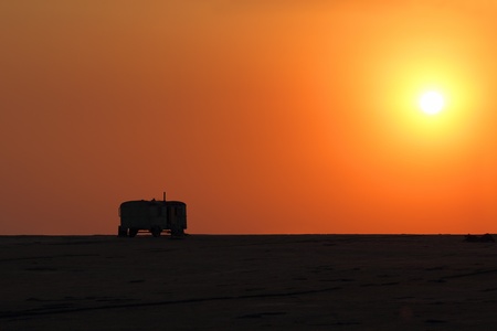 caravan silhouette, standing in the desert under a clear sky at sunset.の写真素材