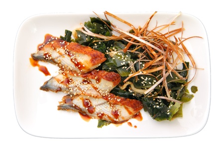 sashimi unagi with slices of smoked eel on algae on rectangular dish over white background. Top...