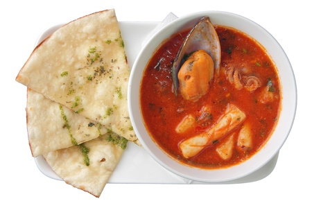 red  soup with seafood in white bowl with pieces of with focaccia on rectangular plate isolated on white backgroundの写真素材