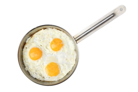 three fried eggs on stainless steel pan isolated on a white backgroundの写真素材