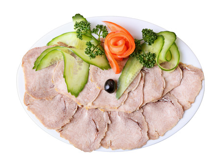 slices of tongue with greens and vegetables  on  white elliptical dishの写真素材