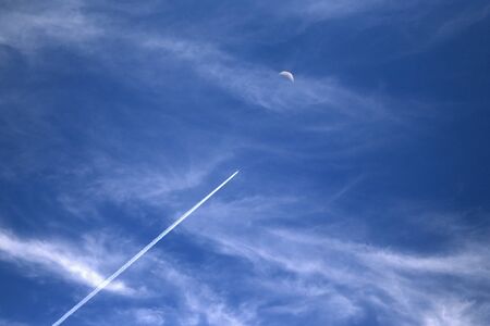 airplane leaving a trail  flies to the moon.の写真素材