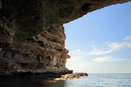 View from a cave in layered cliffs of cape Tarhankut. Crimea.