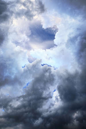 View to the dar blue sky throu a gap in the cloudsの写真素材