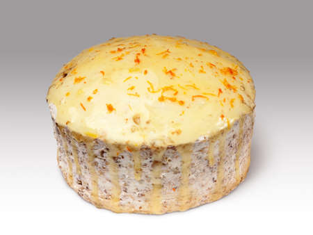 biscuit creamy cake glazed with translucent yellow glaze and decorated with shavings of orange peel over gray backgroundの写真素材