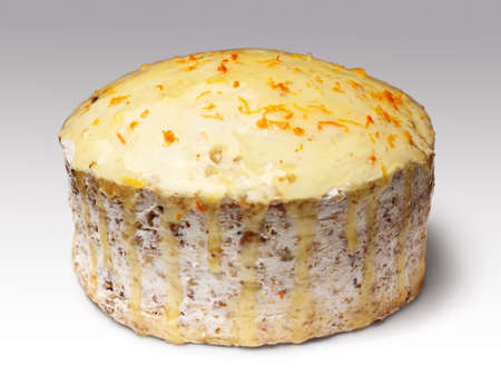 biscuit creamy cake glazed with translucent yellow glaze and decorated with shavings of orange peel over gray backgroundの写真素材