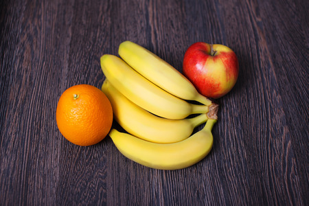 Fruit variety on table orange banana apple on a wooden surfaceの写真素材