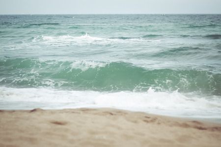 low angle image of shells on the beach and tropical sea waves. filtered imageの写真素材