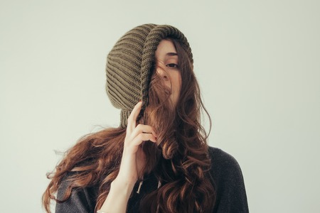 Portrait of playful woman in knitted winter cap smilingの写真素材