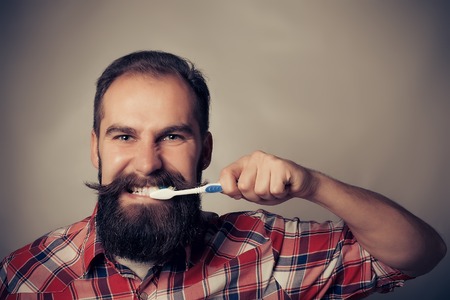 Man washing his teeth in front of the mirrorの写真素材