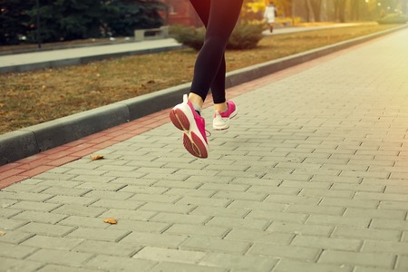 Fitness Girl running at sunset in city centerの写真素材