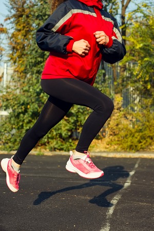Young woman running at a track and field stadium