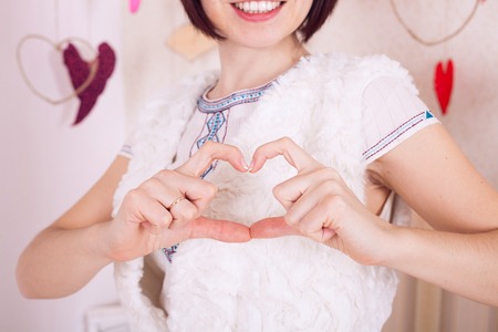 The girl shows a gesture of his hands in the form of heartの写真素材