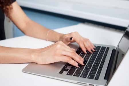 Closeup portrait of woman's hand typing on computer keyboard