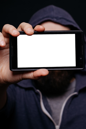 Hipster man with a beard taking picture smartphone self-portrait, screen view, snapshot studio on a black background, Phone white screenの写真素材