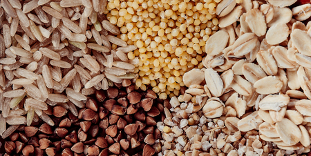 Collection Set of Cereal Grains: Millet, Corn, Rice, Buckwheat, closeup, shot on a wooden surface...