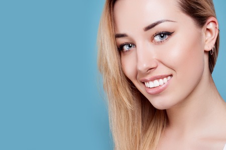 Beautiful woman smiling. portrait of attractive caucasian smiling woman blond on blue studio shot, studio shotの写真素材