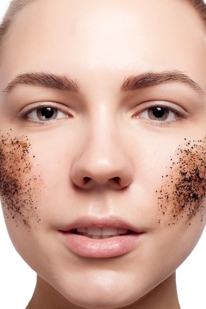 Smiling woman with short hair, bald cleans the skin coffee skrub, studio shot, close-up portraitの写真素材