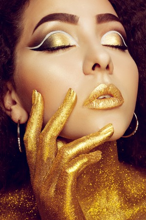 Magic Girl Portrait in Gold. Golden Makeup, close-up portrait in studio shot, colorの写真素材