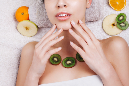 Natural homemade fruit facial masks. Fresh fruit. close-up portrait. beautiful brunette girl with no makeup, natural makeupの写真素材