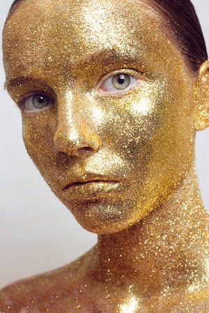 Magic Girl Portrait in Gold. Golden Makeup, close-up portrait in studio shot, colorの写真素材