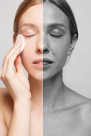 A picture of a happy woman cleaning her face with cotton pads over white background. Beautiful Face of Young Woman with Clean Fresh Skin close up. Beauty Portrait. Youth and Skin Care Conceptの写真素材