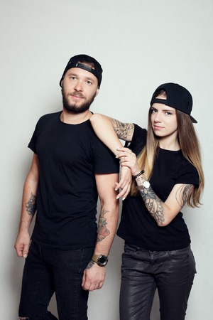 fashion beautiful couple together. Tattoo Hipster boy and girl. Bearded young man and blonde in sunglasses.Yellow backgroundの写真素材