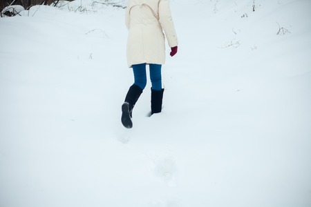 Christmas girl outdoor portrait. Winter woman blowing snow in a park. Flying Snowflakes. Sunny day. Backlit. Beauty young woman Having Fun in Winter Park. Good moodの写真素材