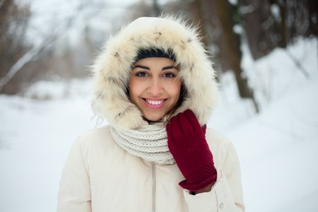 Christmas girl outdoor portrait. Winter woman blowing snow in a park. Flying Snowflakes. Sunny day....