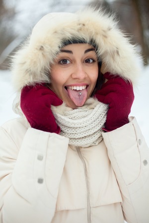 Christmas girl outdoor portrait. Winter woman blowing snow in a park. Flying Snowflakes. Sunny day....
