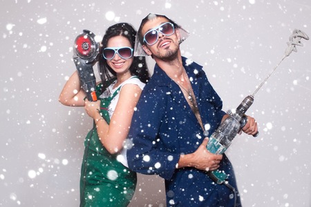 love, winter, christmas, people concept- Male and female construction workers family, happy, interior, new, renovation, young over snow backgroundの写真素材