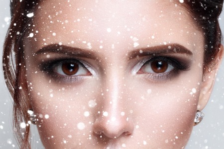 winter, christmas, people, beauty concept- close-up of beautiful womanish eye fashion . half-face, cropped pictures over snow backgroundの写真素材