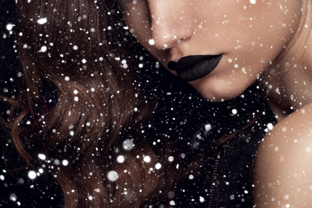 winter, christmas, people, beauty concept- Beauty Black Lip Makeup, Beauty Fashion Model Girl with Black Make up, Long Lushes. Fashion Trendy Caviar Black Manicure. over snow backgroundの写真素材