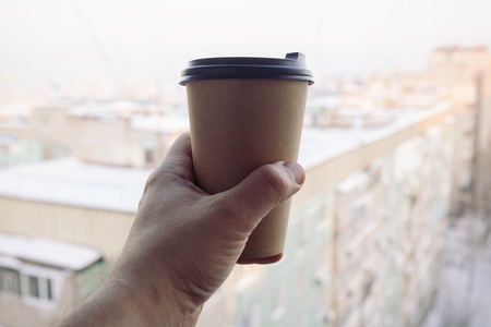 business, lifestyle, food and coffee concept - man holding a paper coffee cupの写真素材