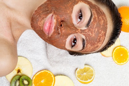 spring, health, people, youth and beauty concept -Natural homemade fruit facial masks. Fresh fruit. Spa Woman applying Facial cleansing Mask. Beauty Treatmentsの写真素材