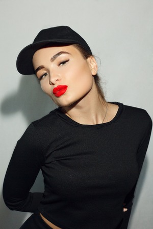 portrait, emotions, people, beauty concept - Fashion art studio portrait woman with red lips. Fashionable lipstick. Professional cosmetic. Portrait of beauty in black dress with big sexy lips.の写真素材