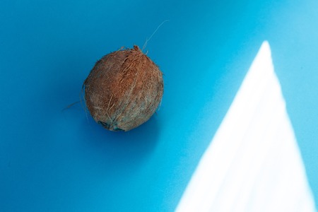 Food, minimalism, color, still life and natural concept - Coconut isolated on blue Background. Clipping Pathの写真素材