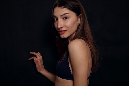 Beautiful sexy female body, healthy breast, beauty and health care concept- close up of sexy female body in black lace underwear over black backgroundの写真素材