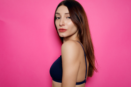 people, emotions, natural, beauty and lifestyle concept - young sexy woman in lingerie posing on pink backgroundの写真素材
