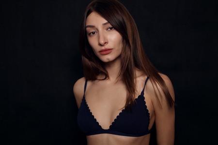 Beautiful sexy female body, healthy breast, beauty and health care concept- close up of sexy female body in black lace underwear over black backgroundの写真素材