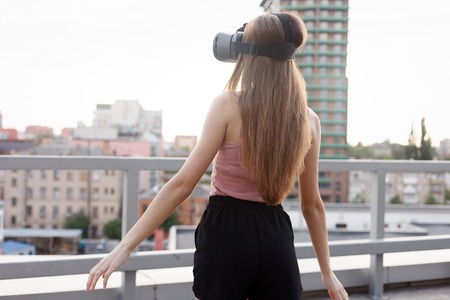 business,technologies, VR, people and lifestyle concept - amazed young beautiful girl using new VR technology VR gear on market amazing sights on oculus headset 3D video glasses VR headset 360 videoの写真素材