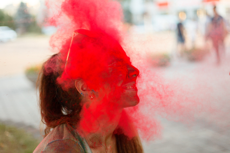 emotions, people, beauty, fashion and lifestyle concept - Portrait of a beautiful girl full of colored powder all over the bodyの写真素材
